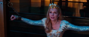 Movie still from “Oz the Great and Powerful” (2013), directed by Sam Raimi – A woman wearing a crown and a white dress; Medium shot, Over the shoulder angle