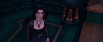 Movie still from “Oz the Great and Powerful” (2013), directed by Sam Raimi – A woman wearing a black dress and a green necklace; Medium shot, Overhead angle