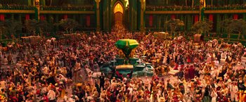 Movie still from “Oz the Great and Powerful” (2013), directed by Sam Raimi – A crowd of people gathered in a large room; Extreme Wide shot, High angle