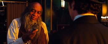 Movie still from “Oz the Great and Powerful” (2013), directed by Sam Raimi – An old man with a long beard is talking to a young man; Close Up shot, Over the shoulder angle
