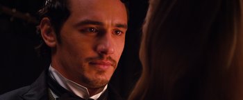 Movie still from “Oz the Great and Powerful” (2013), directed by Sam Raimi – A person wearing a suit and tie; Close Up shot, Over the shoulder angle