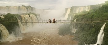 Movie still from “Paddington 2” (2017), directed by Paul King – Two bears are sitting on a suspension bridge over a waterfall; Extreme Wide shot, Low angle