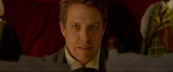 Movie still from “Paddington 2” (2017), directed by Paul King – A person wearing a suit and tie; Close Up shot, Over the shoulder angle