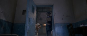 Movie still from “Paddington 2” (2017), directed by Paul King – A man and a dog in a jail cell; Wide shot, High angle