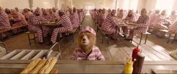Movie still from “Paddington 2” (2017), directed by Paul King – A bear in a pink and white striped pajamas; Wide shot, High angle