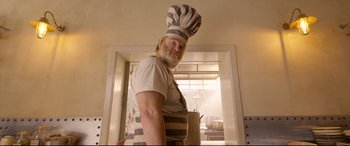 Movie still from “Paddington 2” (2017), directed by Paul King – A man wearing a chef's hat in a kitchen; Medium shot, Low angle