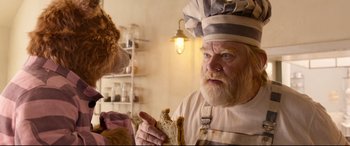Movie still from “Paddington 2” (2017), directed by Paul King – An old man holding a piece of bread in his hand; Close Up shot, Over the shoulder angle