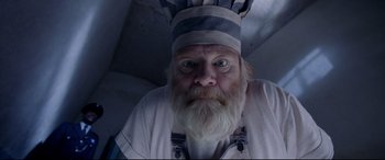 Movie still from “Paddington 2” (2017), directed by Paul King – An old man with a beard wearing a chef's hat; Close Up shot, Low angle