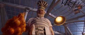 Movie still from “Paddington 2” (2017), directed by Paul King – A statue of an old man dressed as a chef; Medium shot, Low angle