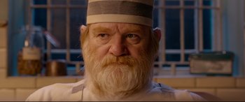 Movie still from “Paddington 2” (2017), directed by Paul King – An old man with a beard wearing a striped hat; Close Up shot, Over the shoulder angle