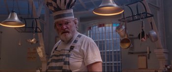 Movie still from “Paddington 2” (2017), directed by Paul King – An old man wearing a chef's hat in a kitchen; Medium shot, Low angle