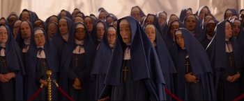 Movie still from “Paddington 2” (2017), directed by Paul King – A large group of women in blue robes and crosses on their heads; Wide shot, High angle