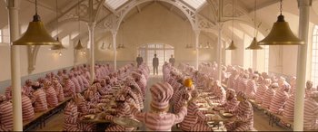 Movie still from “Paddington 2” (2017), directed by Paul King – A group of people sitting around a room; Extreme Wide shot, High angle