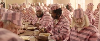 Movie still from “Paddington 2” (2017), directed by Paul King – A group of people in pink and white striped pajamas eating; Medium shot, High angle