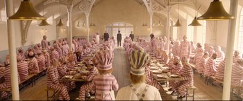 Movie still from “Paddington 2” (2017), directed by Paul King – A group of people sitting at a table with plates of food; Wide shot, High angle