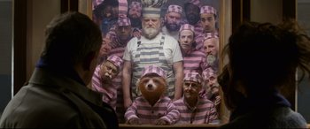 Movie still from “Paddington 2” (2017), directed by Paul King – A group of men in striped shirts and hats; Wide shot, Over the shoulder angle