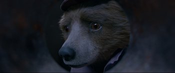 Movie still from “Paddington 2” (2017), directed by Paul King – A brown bear wearing a brown hat and a jacket; Close Up shot, High angle