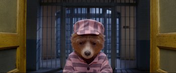 Movie still from “Paddington 2” (2017), directed by Paul King – A brown bear wearing a pink and white striped shirt and hat; Close Up shot, High angle
