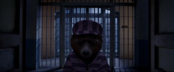 Movie still from “Paddington 2” (2017), directed by Paul King – A teddy bear wearing a hat and pajamas in front of a jail cell; Close Up shot, High angle