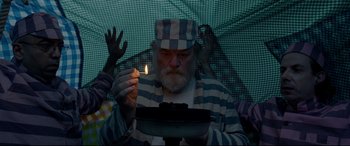 Movie still from “Paddington 2” (2017), directed by Paul King – An old man holding a lit candle in front of an umbrella; Medium shot, Low angle