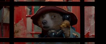 Movie still from “Paddington 2” (2017), directed by Paul King – A bear with a hat on and a phone to his ear; Close Up shot, Overhead angle