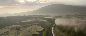 Movie still from “Paddington 2” (2017), directed by Paul King – A train traveling down train tracks near a field; Extreme Wide shot, Low angle