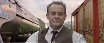 Movie still from “Paddington 2” (2017), directed by Paul King – An older man wearing a vest and tie; Close Up shot, Over the shoulder angle