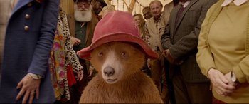 Movie still from “Paddington 2” (2017), directed by Paul King – A brown bear wearing a red hat; Close Up shot, Over the shoulder angle