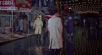 Movie still from “Pal Joey” (1957), directed by George Sidney – A group of people walking down a street at night; Wide shot, High angle