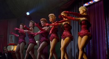 Movie still from “Pal Joey” (1957), directed by George Sidney – A group of women performing a dance on a stage; Wide shot, Low angle