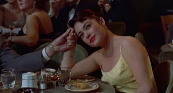 Movie still from “Pal Joey” (1957), directed by George Sidney – A woman sitting at a table with a glass of wine; Close Up shot, High angle