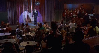 Movie still from “Pal Joey” (1957), directed by George Sidney – A crowd of people sitting and standing in a room; Extreme Wide shot, High angle