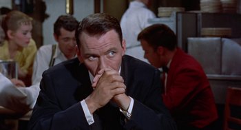 Movie still from “Pal Joey” (1957), directed by George Sidney – A person wearing a suit and tie; Close Up shot, Over the shoulder angle