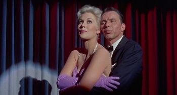 Movie still from “Pal Joey” (1957), directed by George Sidney – An older woman and a younger man posing for a picture; Medium shot, Low angle