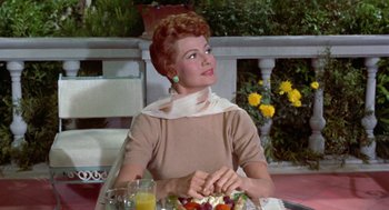 Movie still from “Pal Joey” (1957), directed by George Sidney – A woman sitting at a table with a plate of food; Medium shot, Low angle