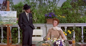 Movie still from “Pal Joey” (1957), directed by George Sidney – A man and a woman sitting at an outdoor table; Medium shot, Low angle