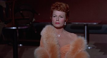 Movie still from “Pal Joey” (1957), directed by George Sidney – A woman in a pink dress and a fur coat; Close Up shot, Low angle