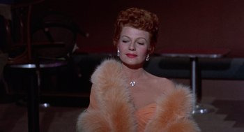 Movie still from “Pal Joey” (1957), directed by George Sidney – A woman in a pink dress and a fur coat; Close Up shot, Low angle