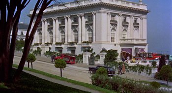 Movie still from “Pal Joey” (1957), directed by George Sidney – An image of an old fashion car parked in front of a building; Extreme Wide shot, Low angle