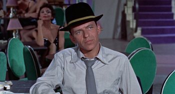 Movie still from “Pal Joey” (1957), directed by George Sidney – A man wearing a black hat and a tie; Close Up shot, Over the shoulder angle