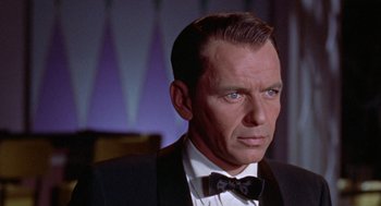 Movie still from “Pal Joey” (1957), directed by George Sidney – An older man in a suit and bow tie; Close Up shot, Over the shoulder angle