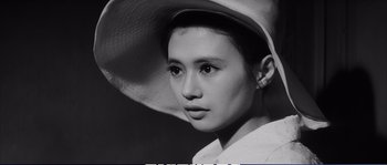 A young woman wearing a hat and looking at the camera