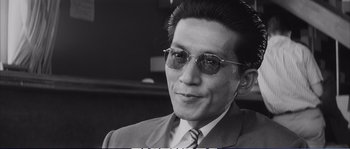 Black and white photograph of a man in a suit and sunglasses