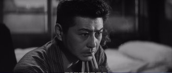A black and white photo of a man smoking a cigarette