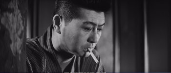 A black and white photo of a man smoking a cigarette