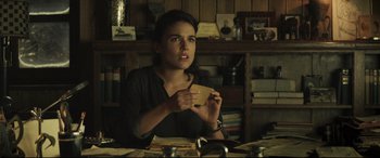 Movie still from “Palm Trees in the Snow” (2015), directed by Fernando González Molina – A woman sitting at a table holding a cup in her hands; Close Up shot, Over the shoulder angle