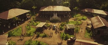 Movie still from “Palm Trees in the Snow” (2015), directed by Fernando González Molina – An aerial view of people walking in front of a house; Extreme Wide shot, High angle