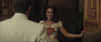 Movie still from “Palm Trees in the Snow” (2015), directed by Fernando González Molina – A woman in a floral dress smiling for the camera; Close Up shot, Over the shoulder angle