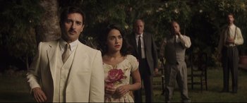 Movie still from “Palm Trees in the Snow” (2015), directed by Fernando González Molina – A man and a woman standing next to each other in front of trees; Medium shot, Over the shoulder angle