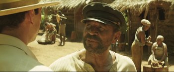 Movie still from “Palm Trees in the Snow” (2015), directed by Fernando González Molina – An older man wearing a hat and a white shirt; Close Up shot, Over the shoulder angle